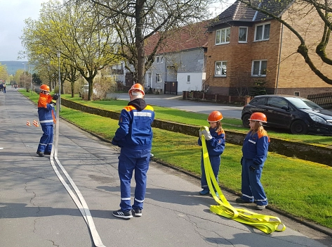 Nach einer Geschicklichkeitsübung rollen die Jugendlichen die Schläuche auf.&nbsp;&copy;&nbsp;Feuerwehr Stadt Uslar