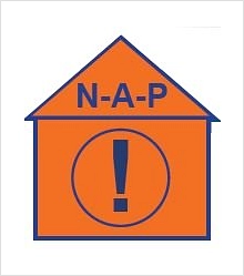 NAP Standort Die Kennzeichnung für einen Notfall-Anlauf-Punkt erfolgt durch ein oranges Symbol in Hausform. Es ist beschriftet mit den Buchstaben NAP und einem Ausrufungszeichen.
